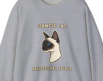 May include: A light gray sweatshirt featuring a Siamese cat illustration with blue eyes. The text "SIAMESE CAT" is above the cat image, and "PROFESSIONAL TALKER" is below. The design is centered on the front of the sweatshirt.