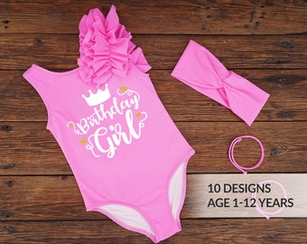 May include: A pink one-piece swimsuit with a ruffled shoulder detail and the text "Birthday Girl" in white. Includes a matching headband and two bracelets. The image also shows "10 Designs" and "Age 1-12 Years".