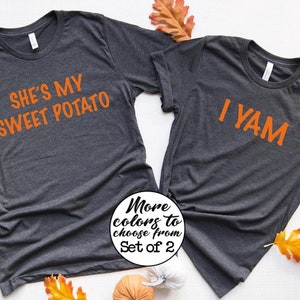 May include: Two grey t-shirts with orange text. One shirt says "She's my sweet potato" and the other says "I yam".