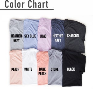 May include: A color chart displaying folded t-shirts in various colors. The colors include heather gray, sky blue, lilac, heather navy, charcoal, peach, white, dark peach, stone, and black. The text "Color Chart" is at the top.