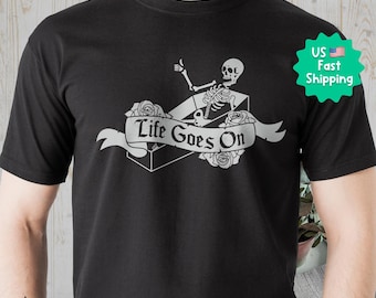 Life Goes On-T-shirt, skelet in een kist, zwaar katoenen shirt. Uniseks T-shirt, grappige grafische casual top, skelet met duim omhoog