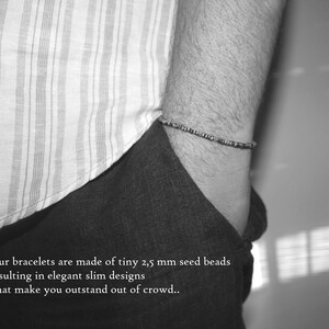 May include: A black and white photo of a person wearing a striped shirt and a bracelet made of tiny seed beads. The text "Our bracelets are made of tiny 2,5 mm seed beads resulting in elegant slim designs that make you outstand out of crowd.." is visible at the bottom of the image.