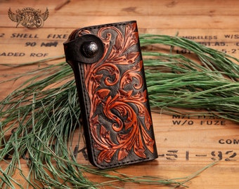 May include: A brown leather key chain with a floral design. The key chain has a snap closure and a metal button.