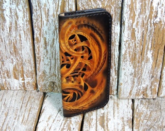 May include: A brown leather wallet with a detailed carved design. The design is intricate and features a swirling pattern.