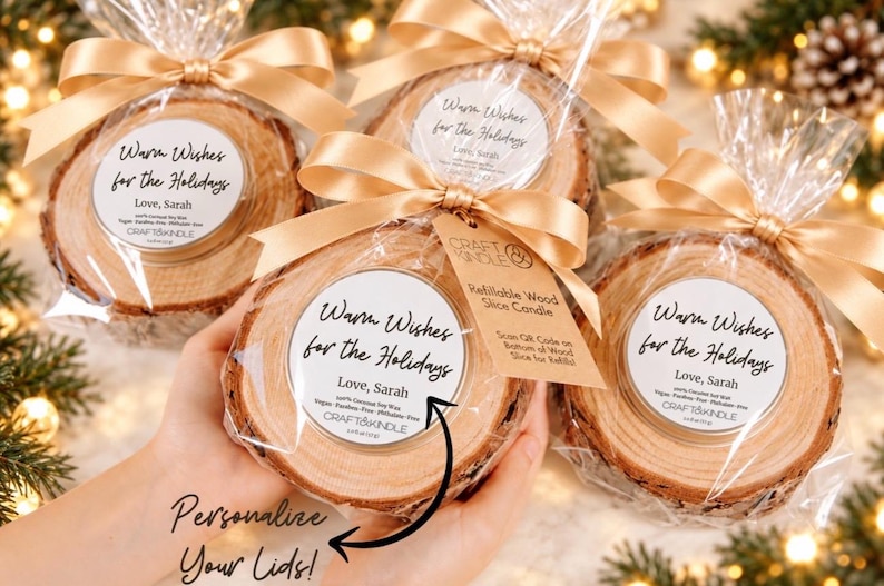 May include: Four round wood slice candles wrapped in clear plastic with gold satin ribbons. Each candle features a white circular label with the text Warm Wishes for the Holidays, Love, Sarah, and Craft & Kindle. One candle includes a tag with instructions.