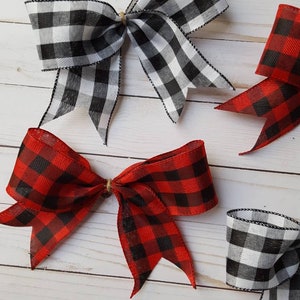 May include: Several decorative bows in a rustic style. Two bows are black and white checkered, and two are red and black checkered. The bows are tied with twine and are arranged on a light wood-grain surface.