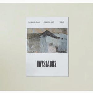 May include: A white poster with the word "HAYSTACKS" in bold black letters. Above the word is an abstract painting in shades of gray, white, and brown. The poster also includes the text "RACHEL LOUISE PEARSON LAKE DISTRICT SERIES EST 2013".
