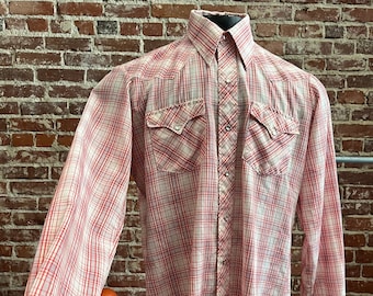 May include: A red and white checked long-sleeved button-up shirt with two chest pockets and a pointed collar.