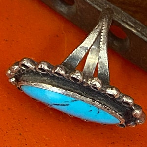 Puede incluir: Un anillo de plata con una piedra turquesa engastada en un engaste de plata. El anillo tiene un dise&ntilde;o simple y elegante y es perfecto para el uso diario.