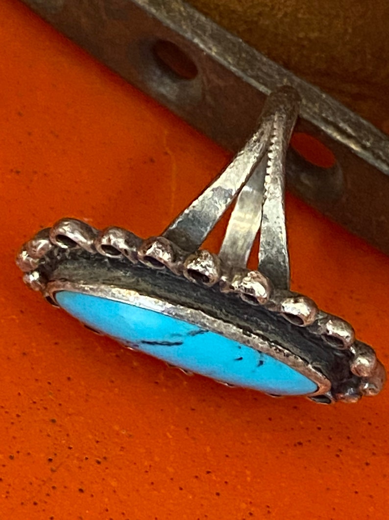 Puede incluir: Un anillo de plata con una piedra turquesa engastada en un engaste de plata. El anillo tiene un dise&ntilde;o simple y elegante y es perfecto para el uso diario.