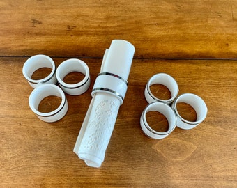 7 White Ceramic Napkin Rings With Silver Trim  On The Top and Bottom