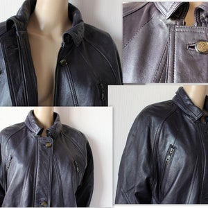 May include: A dark gray leather jacket with a zipper closure and multiple pockets. The jacket has a stand-up collar and a button closure at the neck.