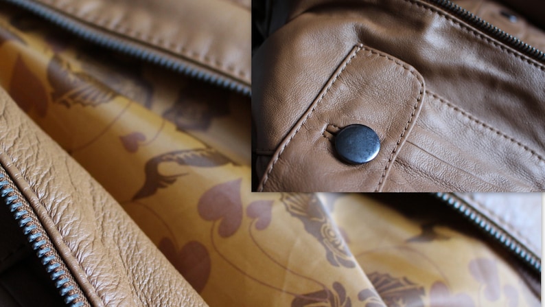May include: Close-up of a brown leather jacket with a zipper and a button closure. The jacket has a patterned lining.