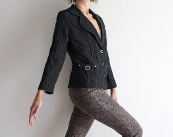 May include: A black blazer with a textured fabric and a single button closure. The blazer has a pocket on the left side with a silver buckle.