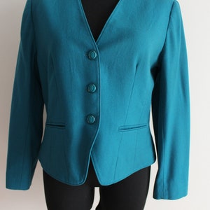 May include: A teal blue blazer with a v-neck and four buttons down the front.