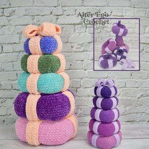 May include: A handmade crochet stacking toy in various colours, including pink, purple, teal, green, and peach. The toy has a ring design and the text "Stacking Toy!" is visible.