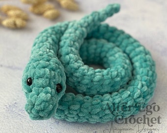 May include: A teal blue crocheted snake amigurumi toy with black eyes. The snake is curled up in a coil shape. The toy is made with a soft, plush yarn.