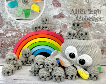 May include: A gray crocheted octopus with large white eyes and yellow and orange accents. The octopus is surrounded by a group of smaller gray crocheted octopuses. A rainbow-colored wooden toy is behind the octopus.