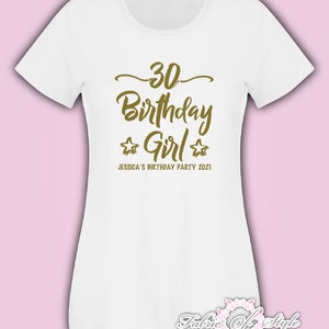 Może przedstawiać: Biała koszulka z złotym napisem "30 Birthday Girl" z dwiema złotymi gwiazdkami po obu stronach słowa "Girl". Pod gł&oacute;wnym napisem znajduje się tekst "Jessica's Birthday Party 2021".