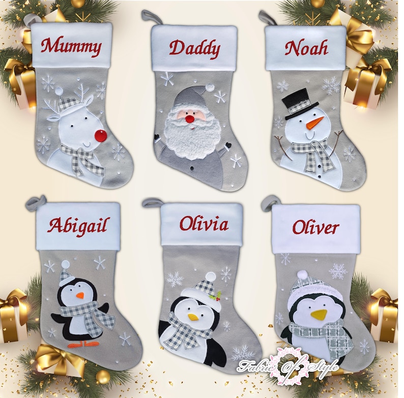 May include: Six gray and white Christmas stockings with personalized names and embroidered designs. The stockings feature a reindeer, Santa Claus, snowman, penguin, and snowflakes.