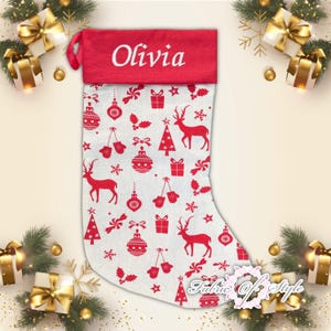 May include: Red and white Christmas stocking with a red felt cuff that says "Olivia". The stocking is decorated with a white background and red Christmas ornaments, reindeer, and trees.
