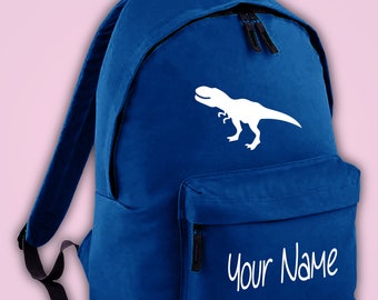 Könnte beinhalten: Royalblauer Rucksack aus Canvas mit einer weißen Dinosauriersilhouette und dem gestickten Text "Your Name" auf der Vorderseite.
