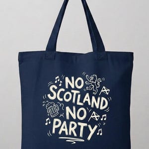 Op de afbeelding: Marineblauwe draagtas met witte tekst en illustraties. De tekst luidt "NO SCOTLAND NO PARTY" met muzieknoten, een bierpul, een Schotse vlag en een leeuwengrafiek. De tas heeft twee handvatten.