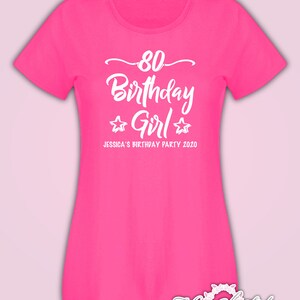 May include: Pink t-shirt with white text that says "80 Birthday Girl" with two stars on either side of the word "Girl". The text below says "Jessica's Birthday Party 2020".
