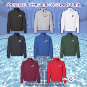Puede incluir: Ocho sudaderas de diferentes colores con cremallera de un cuarto de vuelta, con un gráfico de un nadador y el texto "Your Text" bordado en la parte delantera. Las sudaderas se muestran sobre un fondo de piscina en mosaico.