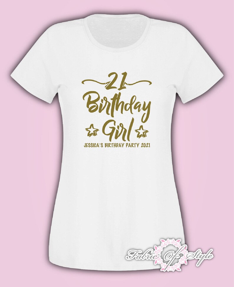 Może przedstawiać: Biała koszulka z złotym napisem "21 Birthday Girl" z dwiema złotymi gwiazdkami po obu stronach słowa "Girl". Pod gł&oacute;wnym tekstem znajduje się napis "Jessica's Birthday Party 2021".