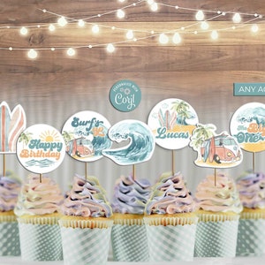 May include: A set of 10 cupcake toppers featuring a beach theme with surfboards, waves, palm trees, and a vintage van. The toppers are personalized with the name "Lucas" and the text "Surf's Up" and "Catch a Wave".