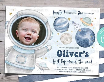 May include: A blue and white astronaut-themed first birthday party invitation with a photo of a baby boy in a space suit. The invitation says "Houston! We have a one year old!" and "Oliver's first trip around the sun!" with details for the party.