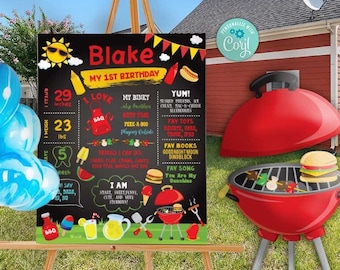 May include: A chalkboard sign with a red and yellow sun graphic, the text "Blake My 1st Birthday", and a list of facts about the birthday boy. The sign is on an easel in a backyard with blue balloons and a red grill.