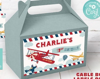 May include: Printable gable box labels featuring a red airplane with a blue and white striped banner that says "Charlie's 1st Birthday". The labels are designed for a gable box and include two sizes: 6.25 inches by 3.5 inches and 5.25 inches by 3.5 inches.