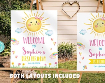 May include: Two printable welcome signs for a first birthday party. The signs feature a yellow sun with a smiling face and a pink bow. The text on the signs reads "Welcome to Sophia's First Birthday".
