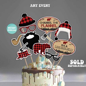 May include: A set of 7 printable photo booth props with a lumberjack theme. The props include a beard, a hat, a pair of glasses, a pipe, a tree stump, a bear, and a speech bubble that says "I'm a Lumber Jill!" The props are printed on white cardstock and are ready to be cut out and used.