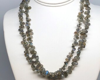 May include: A multi-strand necklace made of gray labradorite gemstone beads. The beads are irregular in shape and have a subtle iridescent shimmer.