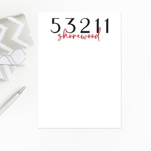 May include: White notepad with the text "53211 shorewood" in black and red lettering.
