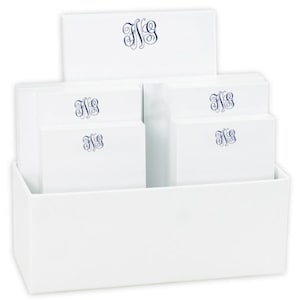 May include: A white desk organizer with a set of five notepads. Each notepad has a blue monogram of the letters "NS" on the front.