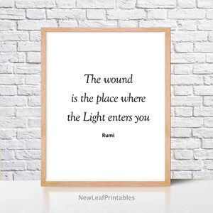 Puede incluir: Una cita imprimible de Rumi, poeta persa del siglo XIII, que dice: "La herida es el lugar donde la Luz entra en ti". La cita est&aacute; impresa en texto negro sobre un fondo blanco y enmarcada en un marco de madera clara.
