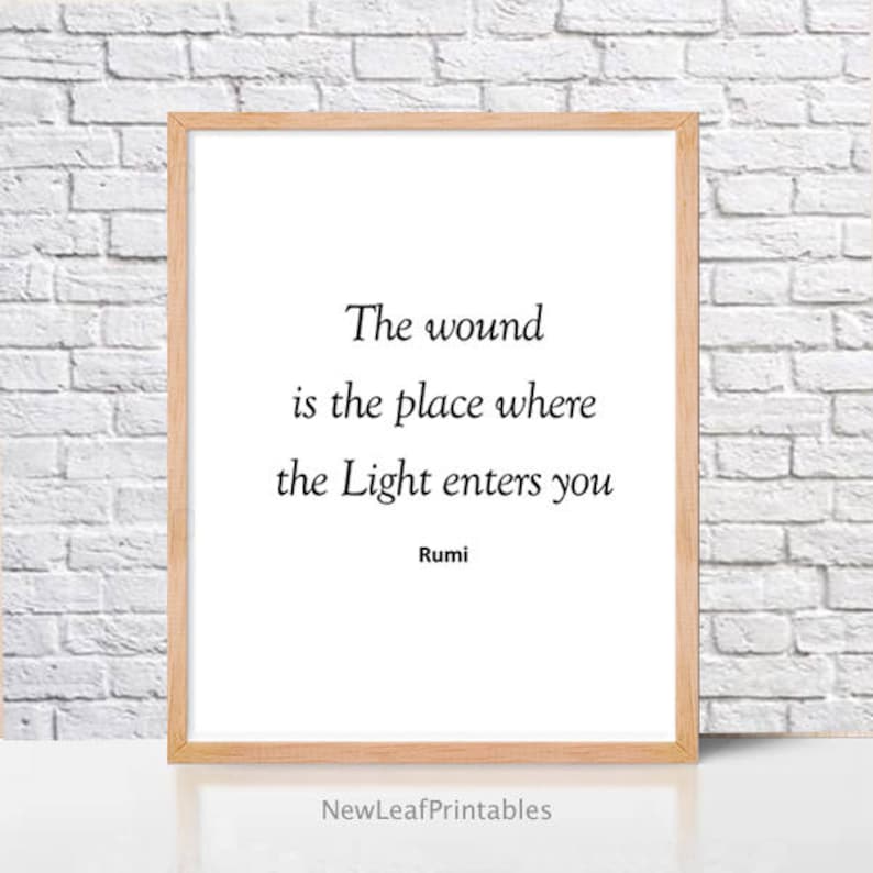 Puede incluir: Una cita imprimible de Rumi, poeta persa del siglo XIII, que dice: "La herida es el lugar donde la Luz entra en ti". La cita est&aacute; impresa en texto negro sobre un fondo blanco y enmarcada en un marco de madera clara.