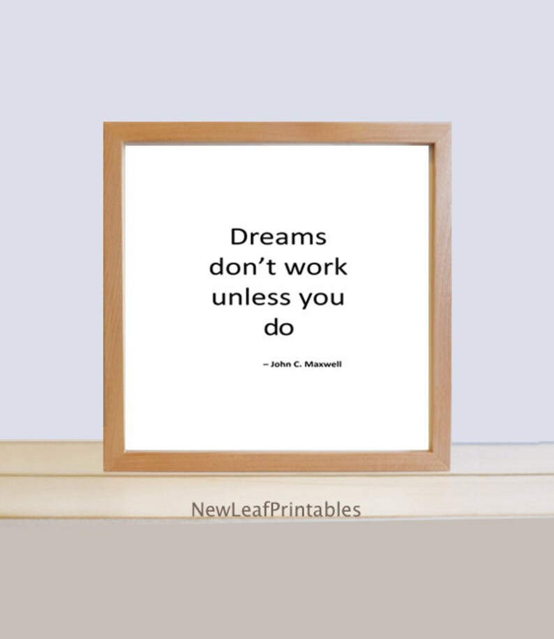 K&ouml;nnte beinhalten: Ein gerahmtes inspirierendes Zitat in einem hellen Holzrahmen. Das Zitat lautet "Tr&auml;ume funktionieren nicht, wenn du es nicht tust" - John C. Maxwell.