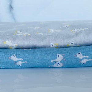 Puede incluir: Dos piezas de tela con un patr&oacute;n de p&aacute;jaros blancos. La tela superior es gris claro y la tela inferior es azul claro.