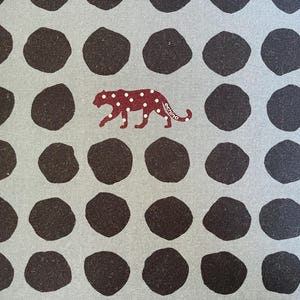 May include: A gray fabric with a repeating pattern of dark brown circles and a burgundy leopard print with the word "echino" printed on the leopard.