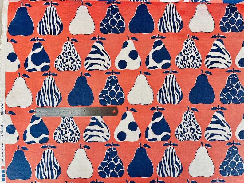 May include: Red fabric with a repeating pattern of white and blue pears. The pears have different patterns, including zebra stripes, leopard spots, and polka dots.