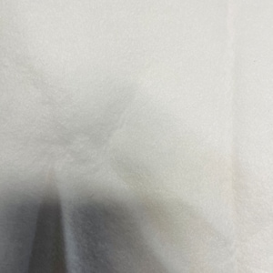 May include: A white, textured fabric surface.