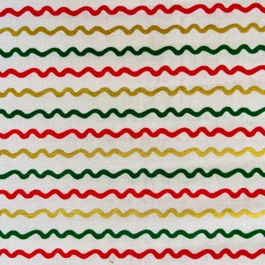 Può includere: Tessuto bianco con linee ondulate in rosso, verde e oro. Le linee sono disposte in un motivo ripetitivo.