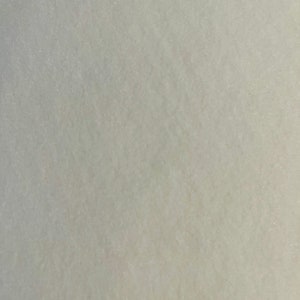 May include: A close-up of a smooth, light grey surface with a subtle texture. The surface appears to be made of a fine-grained material.