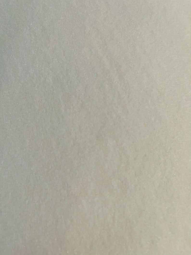 May include: A close-up of a smooth, light grey surface with a subtle texture. The surface appears to be made of a fine-grained material.