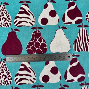 May include: A turquoise fabric with a repeating pattern of pears. The pears are in various shades of brown and white and have different patterns, including leopard print, zebra stripes, and polka dots.